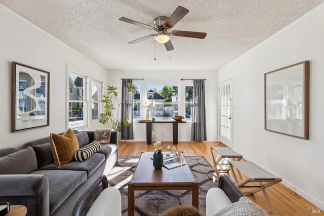 a living room with furniture ceiling fan and a window