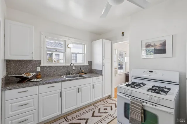 a kitchen with granite countertop cabinets stove and sink