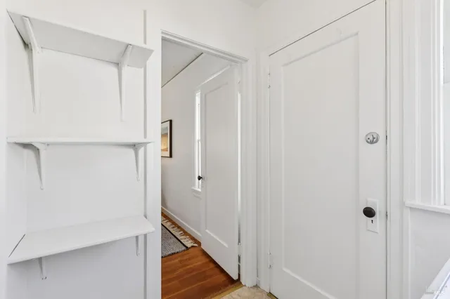 a view of a hallway with wooden floor and entryway