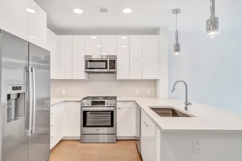 a kitchen with stainless steel appliances a stove sink and refrigerator