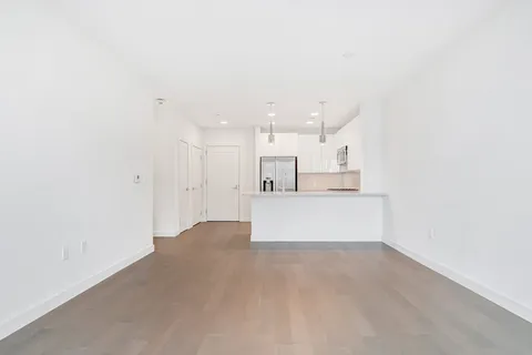 a view of kitchen with kitchen island white cabinets and wooden floor