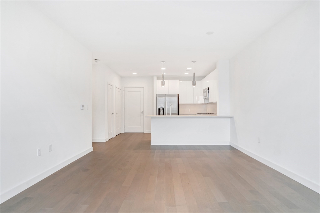 45 Lewis Street, Unit 406 Boston, MA 02128 - Photo 9 of 26 a view of kitchen with kitchen island white cabinets and wooden floor