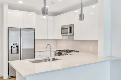 a kitchen with kitchen island a sink stainless steel appliances and cabinets