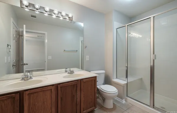 a bathroom with a double vanity sink toilet and shower