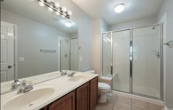 a bathroom with a granite countertop sink a toilet and shower