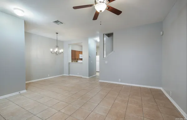 a view of an empty room with a chandelier fan