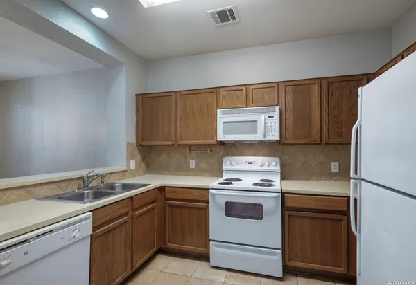 a kitchen with a sink stove and refrigerator