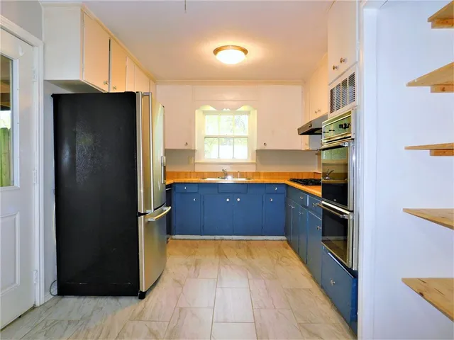 a kitchen with stainless steel appliances granite countertop a refrigerator and a sink