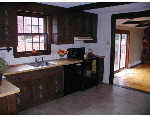 76 Wagon Wheel Road Dracut, MA 01826 - Photo 10 of 10 a kitchen with a sink wooden cabinets and a window