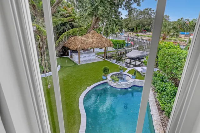 a view of a swimming pool with lawn chairs under an umbrella