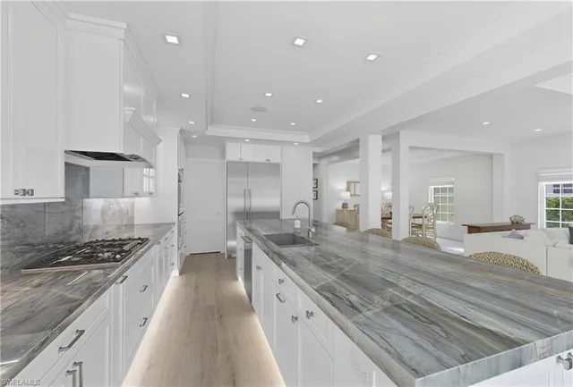 a large kitchen with stainless steel appliances lots of counter top space and wooden floor