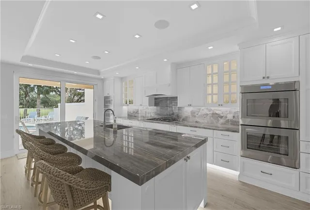 a kitchen with stainless steel appliances granite countertop a stove a sink a microwave and a refrigerator