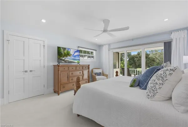 a bedroom with a bed and a large window