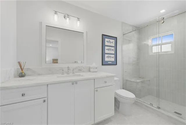 a bathroom with a granite countertop sink a toilet and a mirror