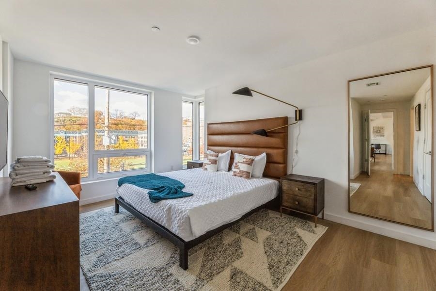 401 Jackson Street, Unit 507 Hoboken, NJ 07030 - Photo 20 of 29 a bedroom with a bed and wooden floor