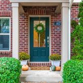 a view of a brick house with a large window and potted plants