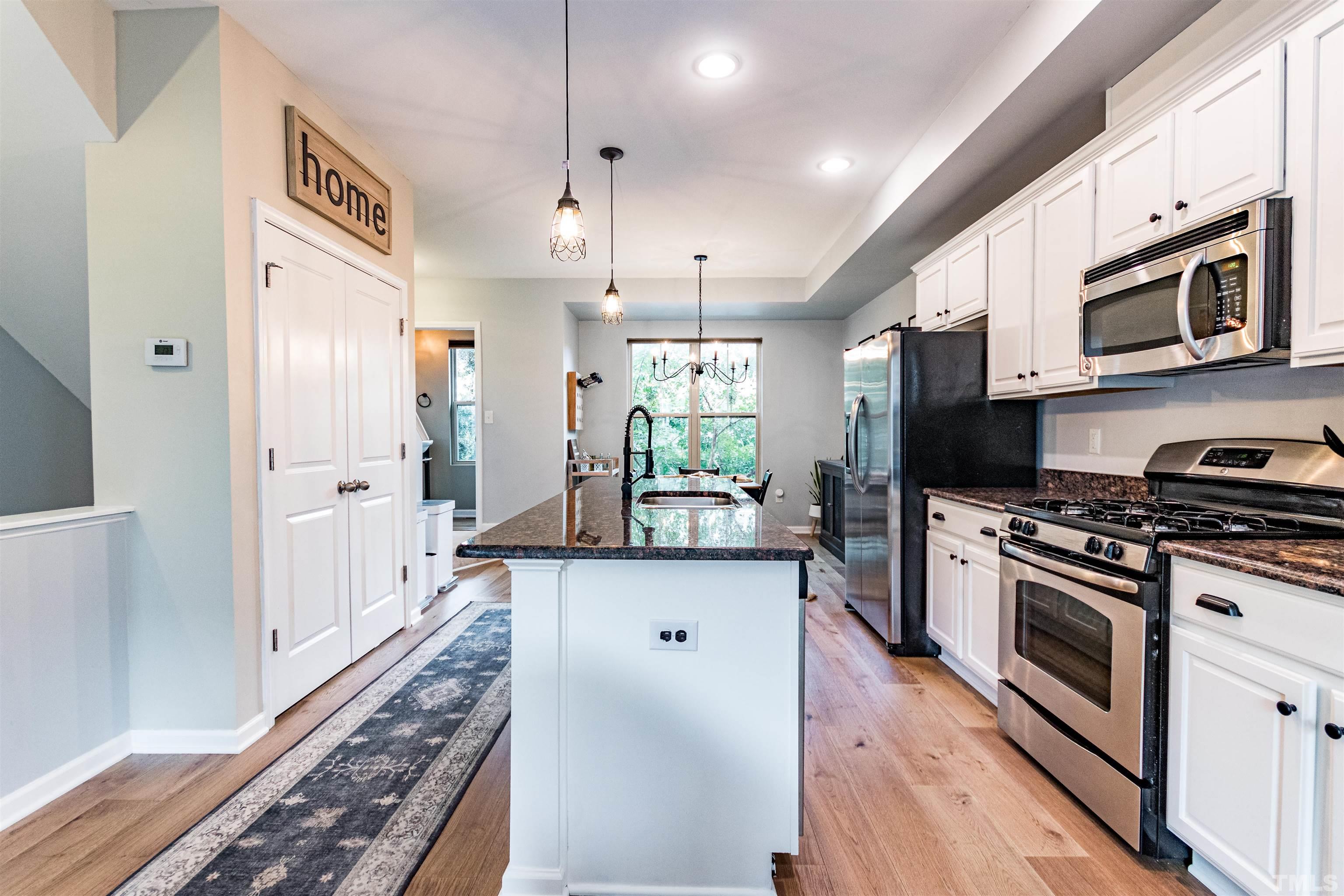 a kitchen with stainless steel appliances a stove a sink and a refrigerator