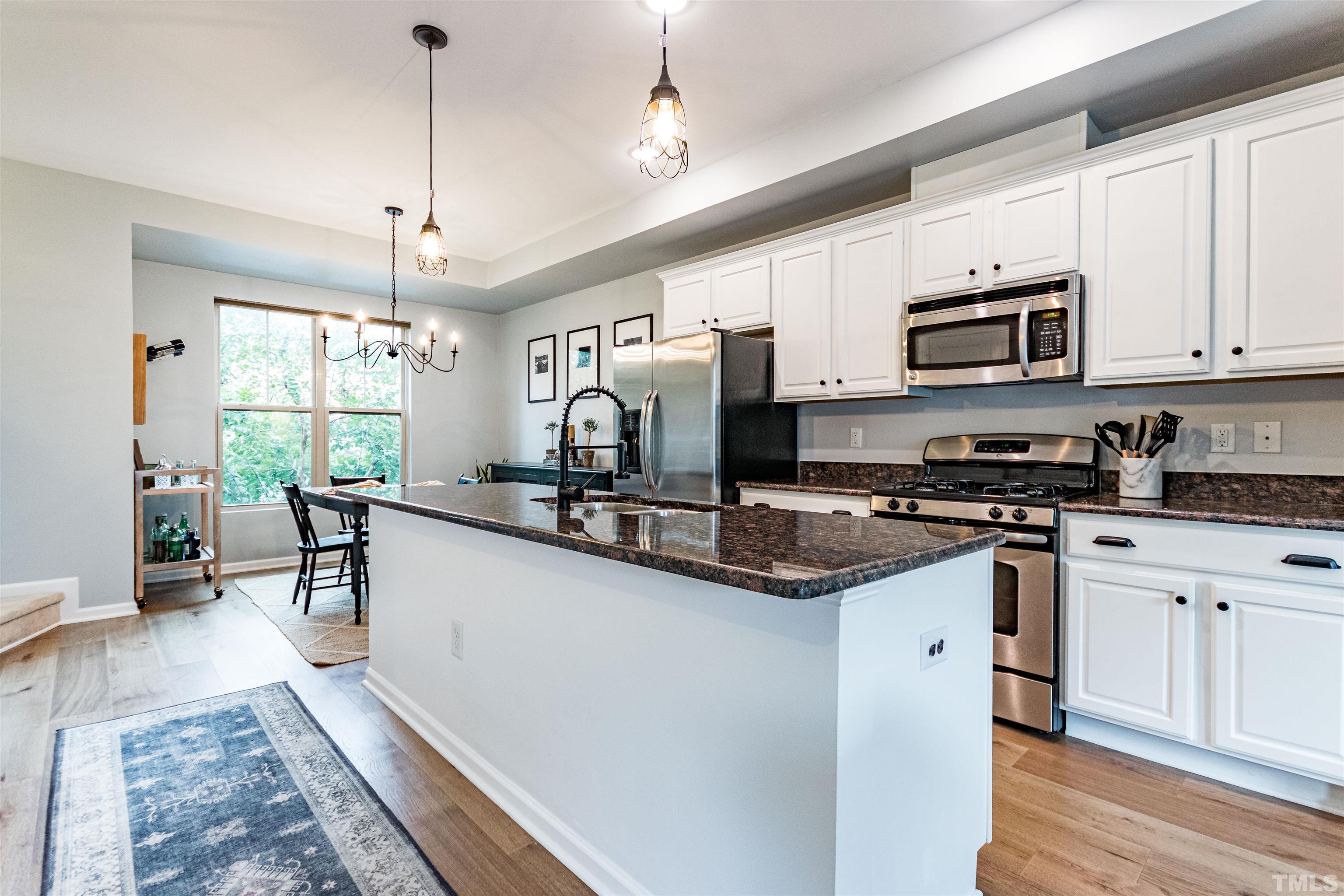 1417 Crafton Way Raleigh, NC 27607 - Photo 7 of 29 a kitchen with stainless steel appliances granite countertop a stove sink refrigerator and cabinets