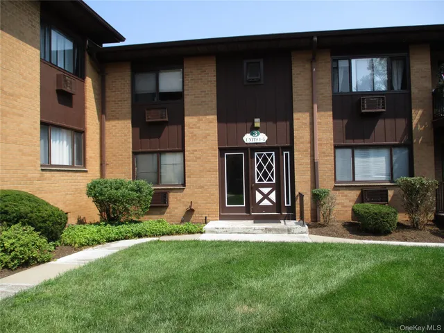 a view of a house with many windows and plants