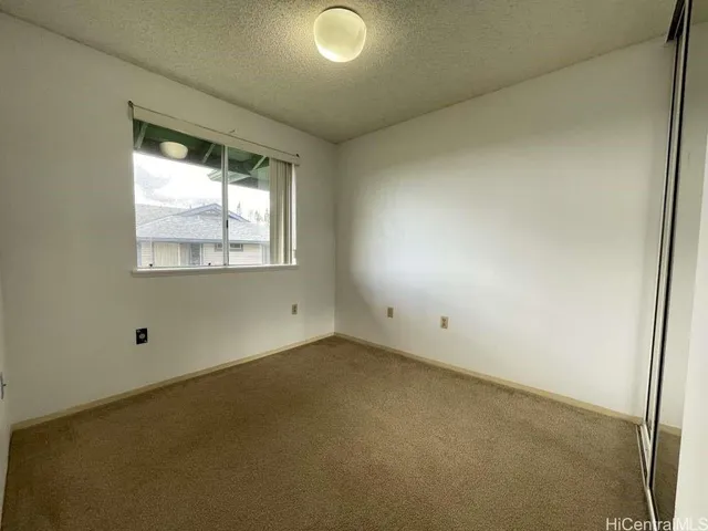 an empty room with closet and a chandelier fan