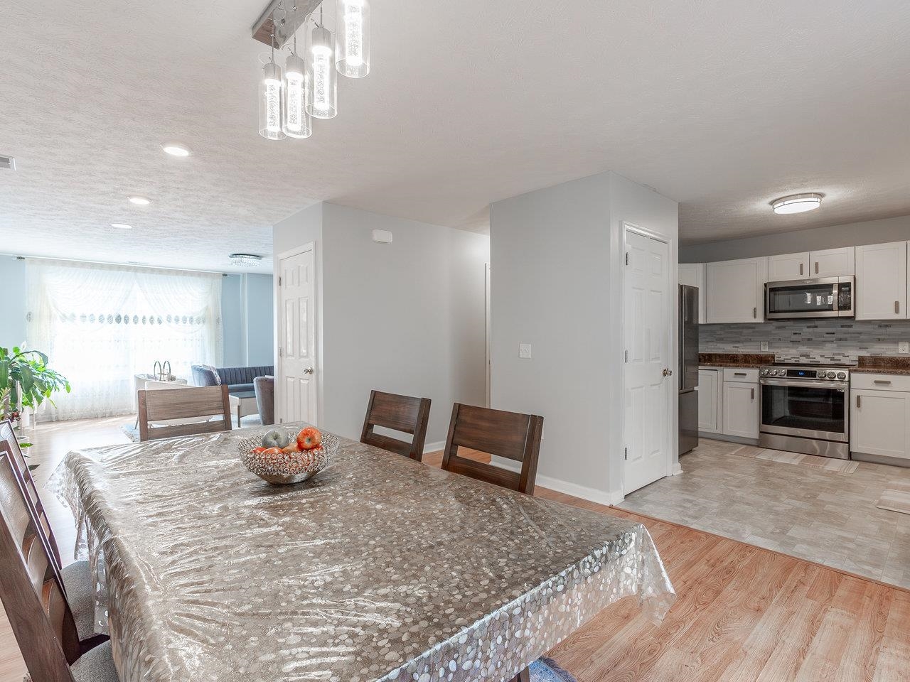 3192 Hebron Court Harrisonburg, VA 22801 - Photo 29 of 75 a kitchen with stainless steel appliances granite countertop a stove top oven a sink dishwasher a dining table and chairs with wooden floor