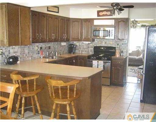 17 Markham Road Edison, NJ 08817 - Photo 2 of 13 a kitchen with stainless steel appliances a stove a sink and a microwave