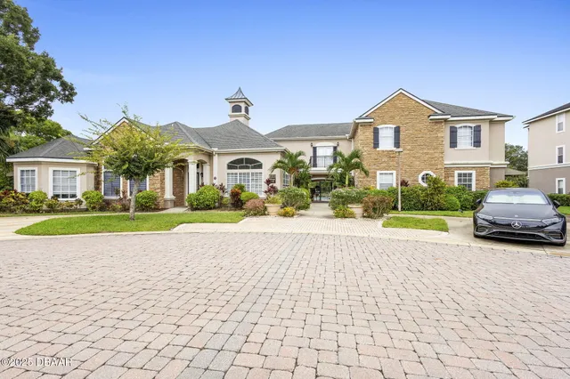 a front view of a house with a yard and potted plants