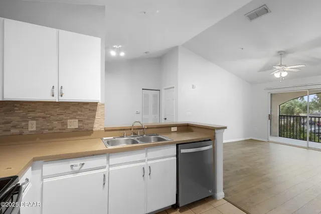a kitchen with stainless steel appliances granite countertop a sink and a white cabinets