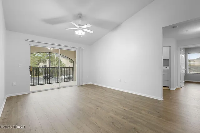 a view of a big room with wooden floor and windows