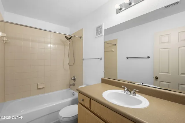 a bathroom with a granite countertop sink toilet tub and shower