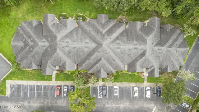 a living room with couches and a flat screen tv with kitchen view