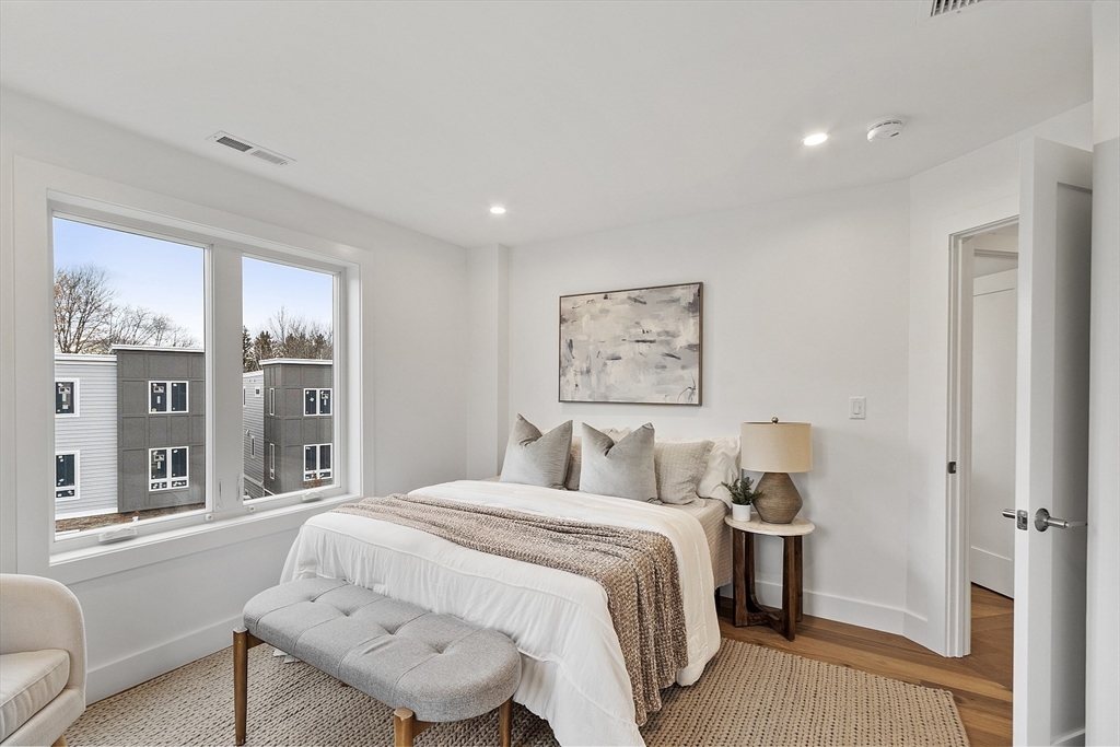 225 Middlesex Turnpike, Unit 106 Burlington, MA 01803 - Photo 15 of 23 a bedroom with a large bed and a couch