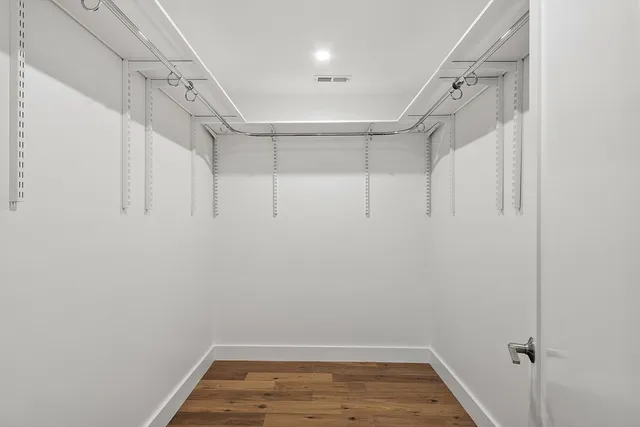 a spacious bedroom with a bed and a painting on the wall