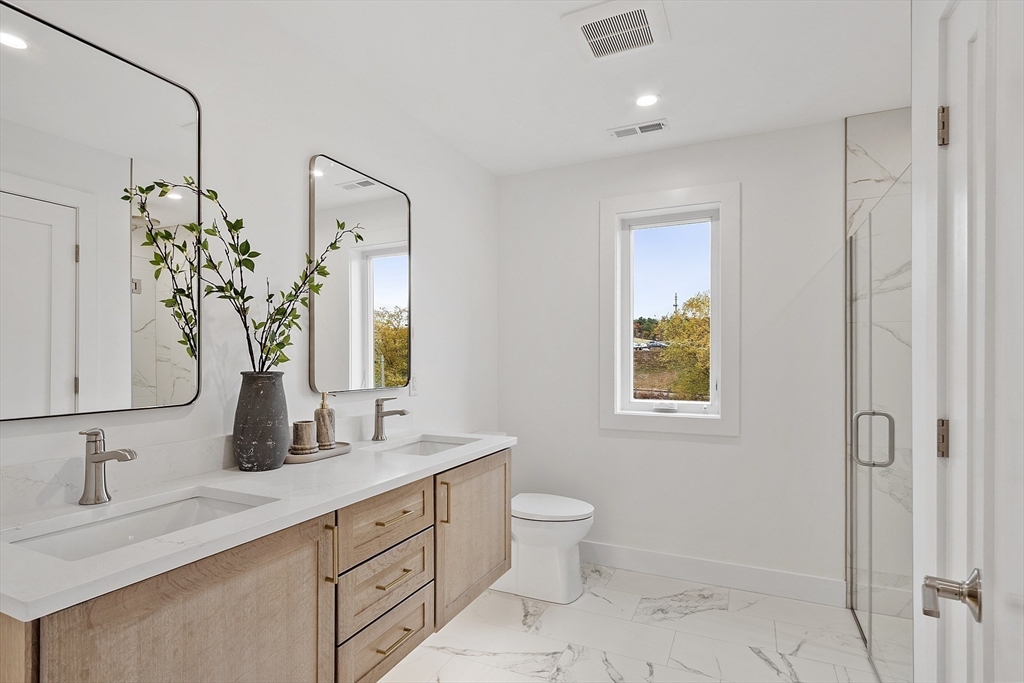 225 Middlesex Turnpike, Unit 106 Burlington, MA 01803 - Photo 20 of 23 a bathroom with a double vanity sink mirror and toilet