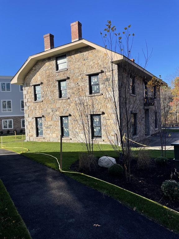 225 Middlesex Turnpike, Unit 106 Burlington, MA 01803 - Photo 3 of 23 a front view of a house with garden