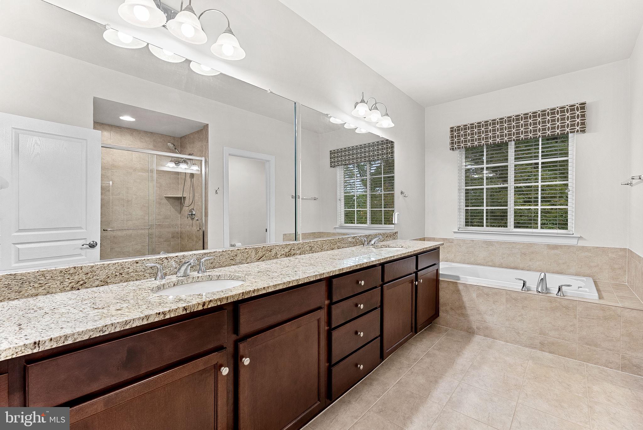 20281 Center Brook Square Sterling, VA 20165 - Photo 25 of 51 a bathroom with a granite countertop double vanity sink a bathtub and a large mirror