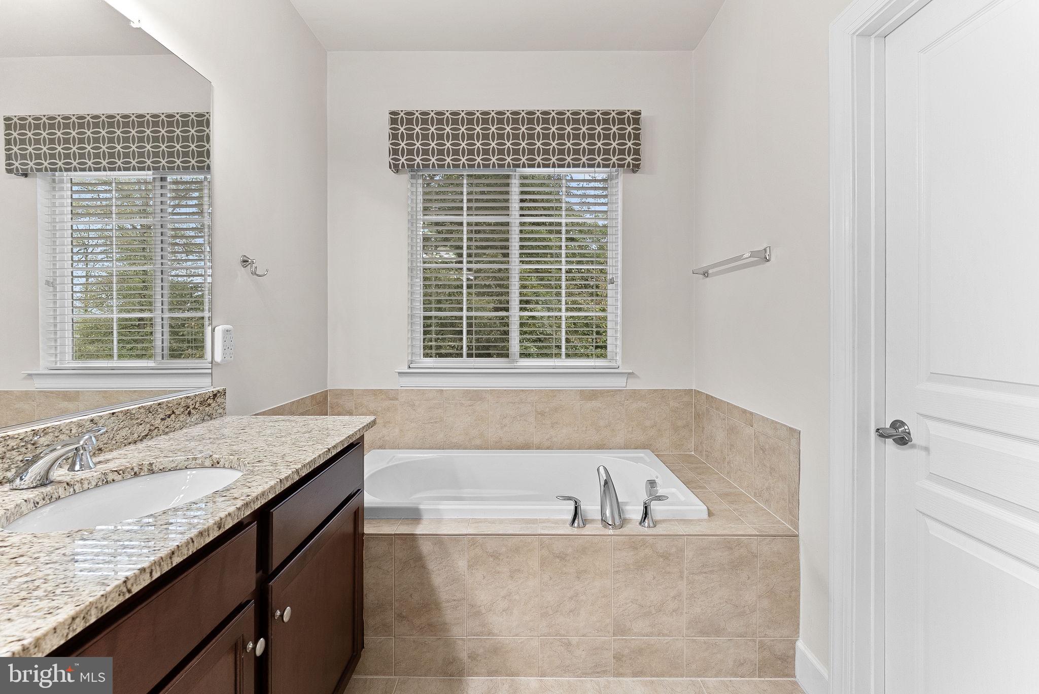 20281 Center Brook Square Sterling, VA 20165 - Photo 26 of 51 a bath tub sitting in a bathroom next to a window
