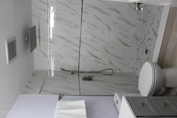 a bathroom with a toilet and a shower