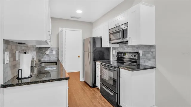 a kitchen with stainless steel appliances granite countertop a stove a refrigerator and a microwave