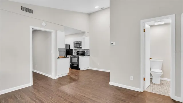 a view of kitchen with white wooden cabinets and refrigerator