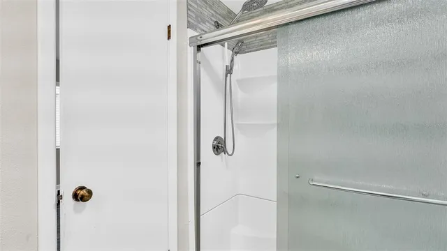 a bathroom with a glass shower door