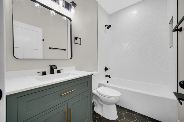 a bathroom with a toilet sink a mirror and bathtub
