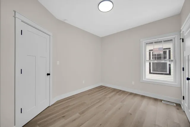 a view of a room that has wooden floor and window