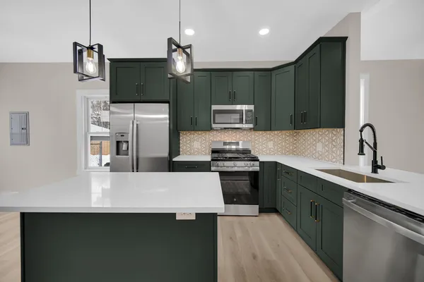 a kitchen with stainless steel appliances a sink stove and refrigerator