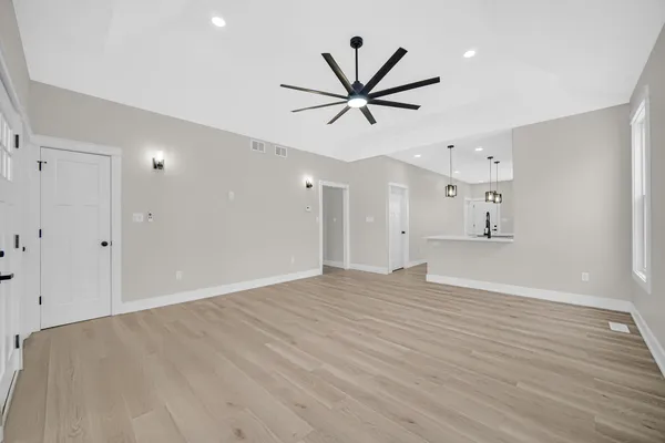 a view of empty room with wooden floor and window
