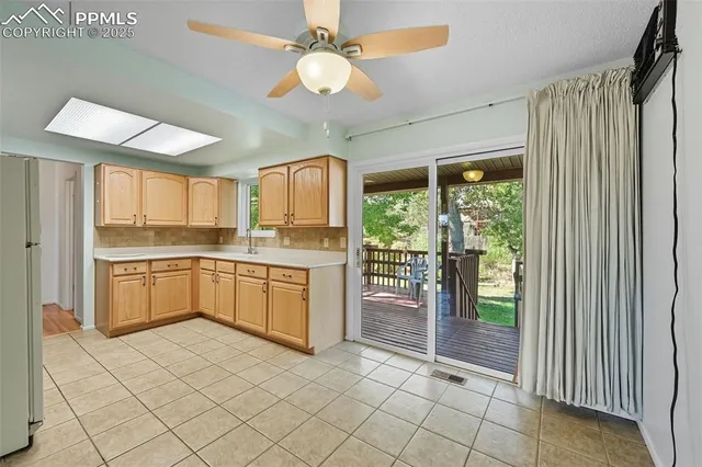 a large white kitchen with a large window and stainless steel appliances