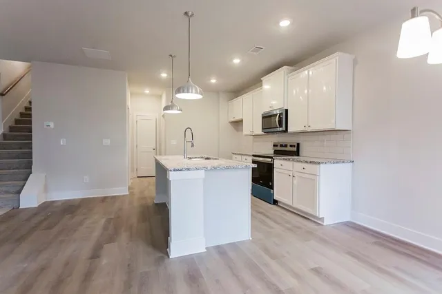 a kitchen with a sink cabinets and wooden floor
