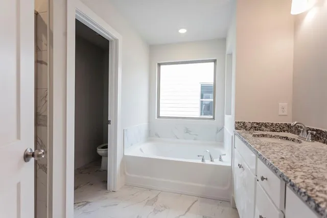 a spacious bathroom with a granite countertop tub sink and mirror
