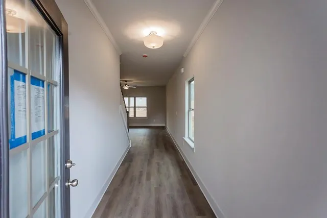 a view of a hallway with wooden floor and staircase