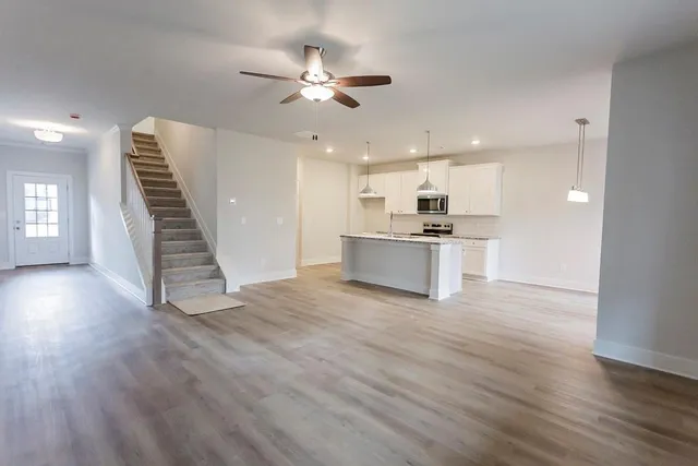 a view of a kitchen with a sink dishwasher oven window and wooden floor